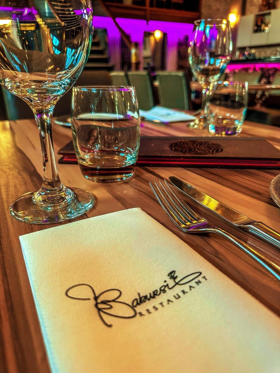 A table set with glasses and a Ba'Bursi menu